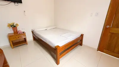 a small bedroom with a small bed and a table at Cabaña Datalu 1 in Coveñas