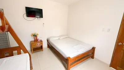 a bedroom with a bed and a tv on the wall at Cabaña Datalu 1 in Coveñas