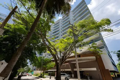 a tall building with a tree in front of it at Lujoso apartamento con jacuzzi - Dominique in Cartagena de Indias