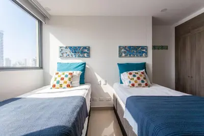 two beds in a room with blue and white at Lujoso Apto de 2 Hab en Piso 14 Morros City in Cartagena de Indias