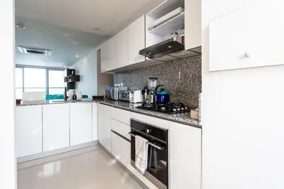 a white kitchen with white cabinets and appliances at Lujoso Apto de 2 Hab en Piso 14 Morros City in Cartagena de Indias