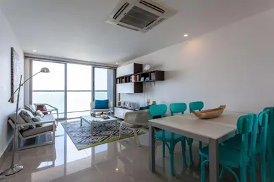 a dining room with a table and green chairs at Lujoso Apto de 2 Hab en Piso 14 Morros City in Cartagena de Indias
