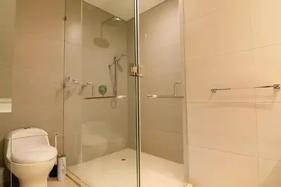 a bathroom with a toilet and a glass shower at Lujoso apto de 1 hab en piso 15 Edificio H2 in Cartagena de Indias