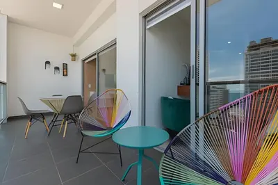 a room with chairs and a table with colorful chairs at Lujoso Apto de 2 habitaciones en piso 16-Infinitum in Cartagena de Indias