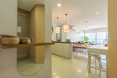 a kitchen and living room with a counter and a table at Lujoso Apto de 2 habitaciones en piso 16-Infinitum in Cartagena de Indias
