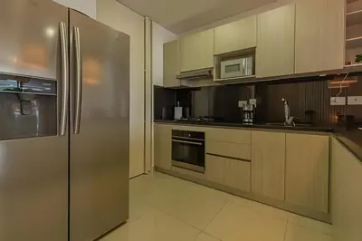 a kitchen with wooden cabinets and a stainless steel refrigerator at Lujoso Apto de 2 habitaciones en piso 16-Infinitum in Cartagena de Indias