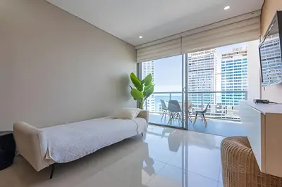 a bedroom with a bed and a balcony at Lujoso Apto de 2 habitaciones en piso 16-Infinitum in Cartagena de Indias