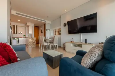 a living room with a blue couch and a tv at Condominio H2-Luxurious 2 BR / 16th F - Bocagrande in Cartagena de Indias
