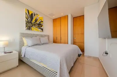a bedroom with a bed and a painting on the wall at Condominio H2-Luxurious 2 BR / 16th F - Bocagrande in Cartagena de Indias