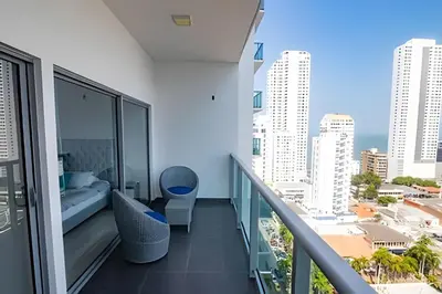a balcony with a bed and a view of the city at Hermoso Apto de 1 hab con Vista al Mar - Piso 16! in Cartagena de Indias