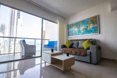 a living room with a couch and a painting on the wall at Hermoso Apto de 1 hab con Vista al Mar - Piso 16! in Cartagena de Indias