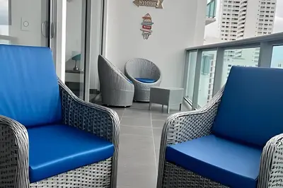 a balcony with wicker chairs in a building at Hermoso Apto de 1 hab con Vista al Mar - Piso 16! in Cartagena de Indias