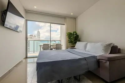 a bedroom with a large bed and a large window at 16th Floor Infinitum 1 Bedroom Apt in Cartagena de Indias