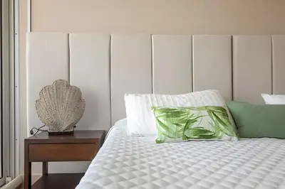 a white bed with a green pillow and a nightstand at Lujoso Apto de 1 Habitación en Piso 17 -H2 Hyatt in Cartagena de Indias