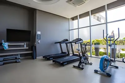 a gym with three tread machines and a flat screen tv at Espectacular Vista desde Piso 17 -Morros City 1701 in Cartagena de Indias