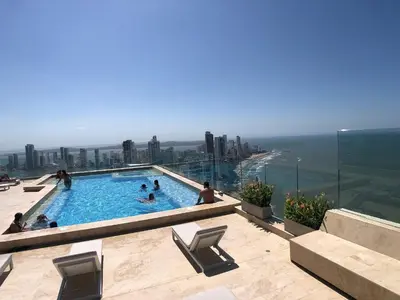 people in a swimming pool on top of a building at Hermoso Apto - 2 Hab Piso- 17 Murano Elite in Cartagena de Indias