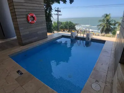 a swimming pool next to a building with the ocean at Hermoso Apto - 2 Hab Piso- 17 Murano Elite in Cartagena de Indias