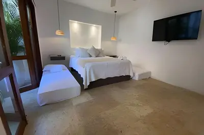 a bedroom with two beds and a flat screen tv at Casa de 3 Hab en la Ciudad Amurallada con Piscina in Cartagena de Indias