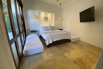 a bedroom with a white bed and a television at Casa de 3 Hab en la Ciudad Amurallada con Piscina in Cartagena de Indias