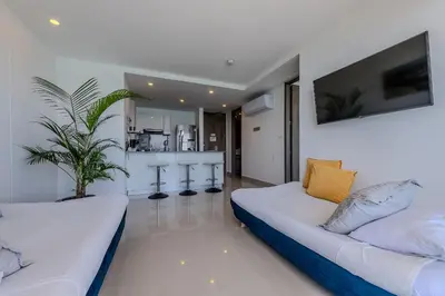 a living room with a couch and a kitchen at 1704 Morros City - Espectacular Apto en Bocagrande in Cartagena de Indias