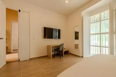 a bedroom with a bed and a desk and a television at Casa Encanto - Corazón de Getsemaní in Cartagena de Indias