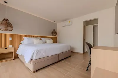 a bedroom with a white bed and a desk at Casa Encanto - Corazón de Getsemaní in Cartagena de Indias