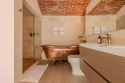 a bathroom with a copper tub and a toilet at Casa Bóvedas - Paraíso de 5 habitaciones in Cartagena de Indias