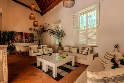 a living room with white furniture and a table at Casa Bóvedas - Paraíso de 5 habitaciones in Cartagena de Indias