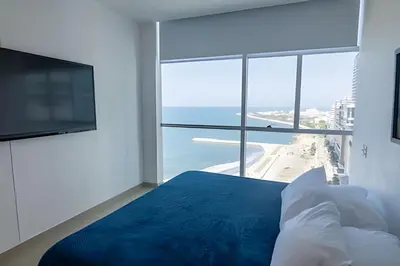 a bedroom with a bed and a view of the ocean at Espectacular Vista Al Mar - Edificio Infinito 1802 in Cartagena de Indias