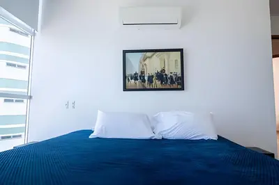 a bedroom with a blue bed with a picture on the wall at Espectacular Vista Al Mar - Edificio Infinito 1802 in Cartagena de Indias