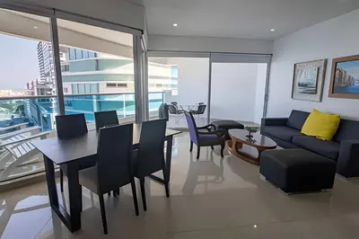 a living room with a couch and a table and chairs at Espectacular Vista Al Mar - Edificio Infinito 1802 in Cartagena de Indias