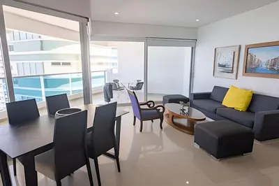 a living room with a couch and a table and chairs at Espectacular Vista Al Mar - Edificio Infinito 1802 in Cartagena de Indias
