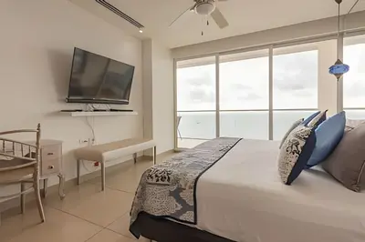 a bedroom with a bed and a flat screen tv at Lujoso Apto con Vista al Mar - H2 Hyatt 1806 in Cartagena de Indias