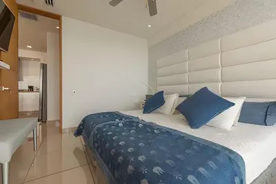 a bedroom with a large bed with blue pillows at Lujoso Apto con Vista al Mar - H2 Hyatt 1806 in Cartagena de Indias