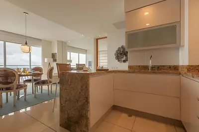 a kitchen with a counter and a dining room at Lujoso Apto con Vista al Mar - H2 Hyatt 1806 in Cartagena de Indias