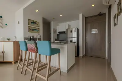 a kitchen with two chairs and a counter with a refrigerator at Espectacular Vista al Mar en Morros City piso 19 in Cartagena de Indias