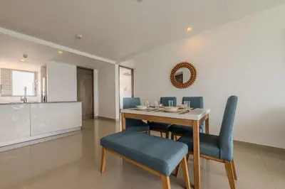 a dining room with a table and blue chairs at Hermoso Apto 2 Hab Piso 19 en Morros City in Cartagena de Indias