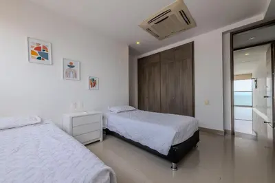 a bedroom with two beds and a sliding glass door at Hermoso Apto 2 Hab Piso 19 en Morros City in Cartagena de Indias