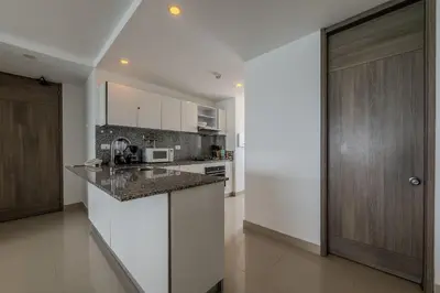 a kitchen with white cabinets and a counter top at Hermoso Apto 2 Hab Piso 19 en Morros City in Cartagena de Indias