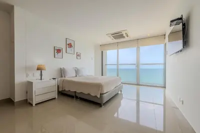 a bedroom with a bed and a view of the ocean at Hermoso Apto 2 Hab Piso 19 en Morros City in Cartagena de Indias