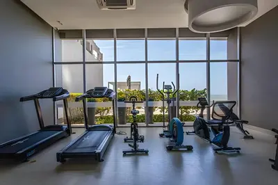 a gym with several treadmills and a large window at Lujoso Apto de 2 Hab en piso 20 - Morros City in Cartagena de Indias