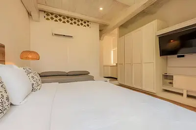 a bedroom with a white bed and a flat screen tv at Casa de 5 Hab en la Ciudad Amurallada con Piscina in Cartagena de Indias