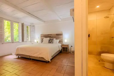 a bedroom with a bed and a bathroom with a toilet at Casa de 5 Hab en la Ciudad Amurallada con Piscina in Cartagena de Indias