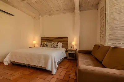 a bedroom with a bed and a couch at Casa de 5 Hab en la Ciudad Amurallada con Piscina in Cartagena de Indias