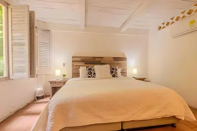 a bedroom with a large bed and a window at Casa de 5 Hab en la Ciudad Amurallada con Piscina in Cartagena de Indias