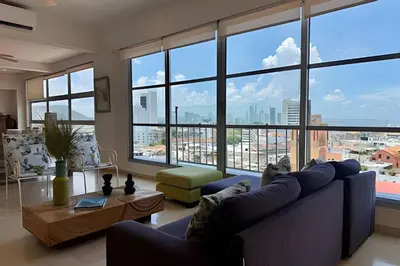 a living room with a blue couch and large windows at Espectacular apto de 2 hab en Centro Histórico in Cartagena de Indias