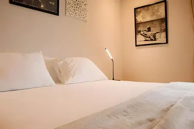 a bedroom with a white bed and a lamp at Relaxing New Apt w/ Balcony in Getsemani! in Cartagena de Indias