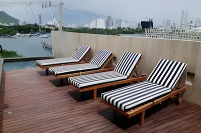 a row of chairs sitting on top of a deck at Relaxing New Apt w/ Balcony in Getsemani! in Cartagena de Indias