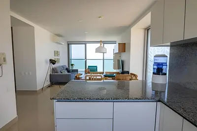 a kitchen with a counter top and a living room at Hermoso Apto Frente al Mar - Morros City piso 9 in Cartagena de Indias