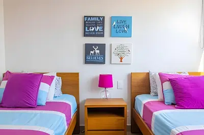 two beds in a room with pink and blue at Hermoso Apto Frente al Mar - Morros City piso 9 in Cartagena de Indias